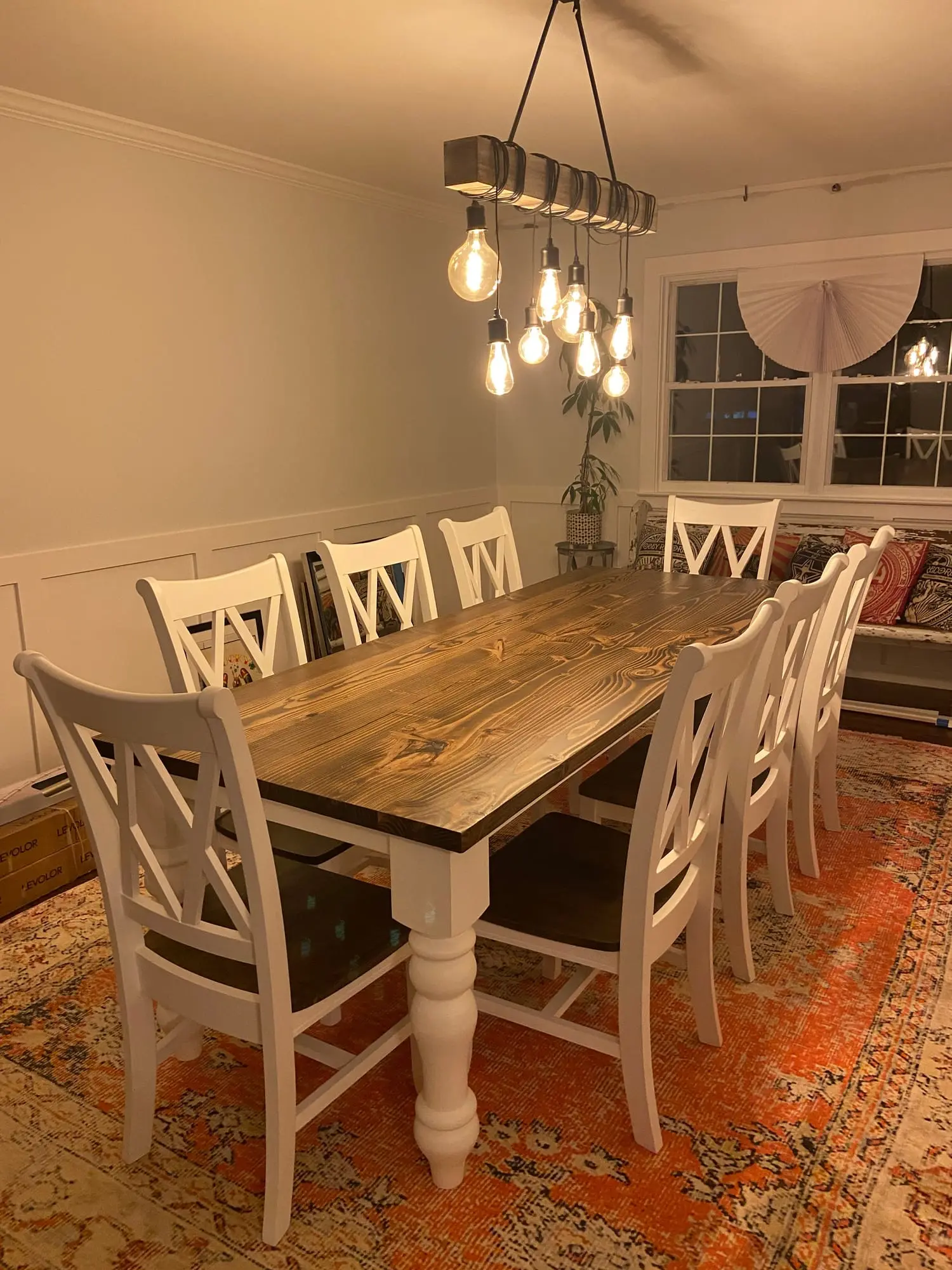 A farm table with white chairs in a customer's dining room