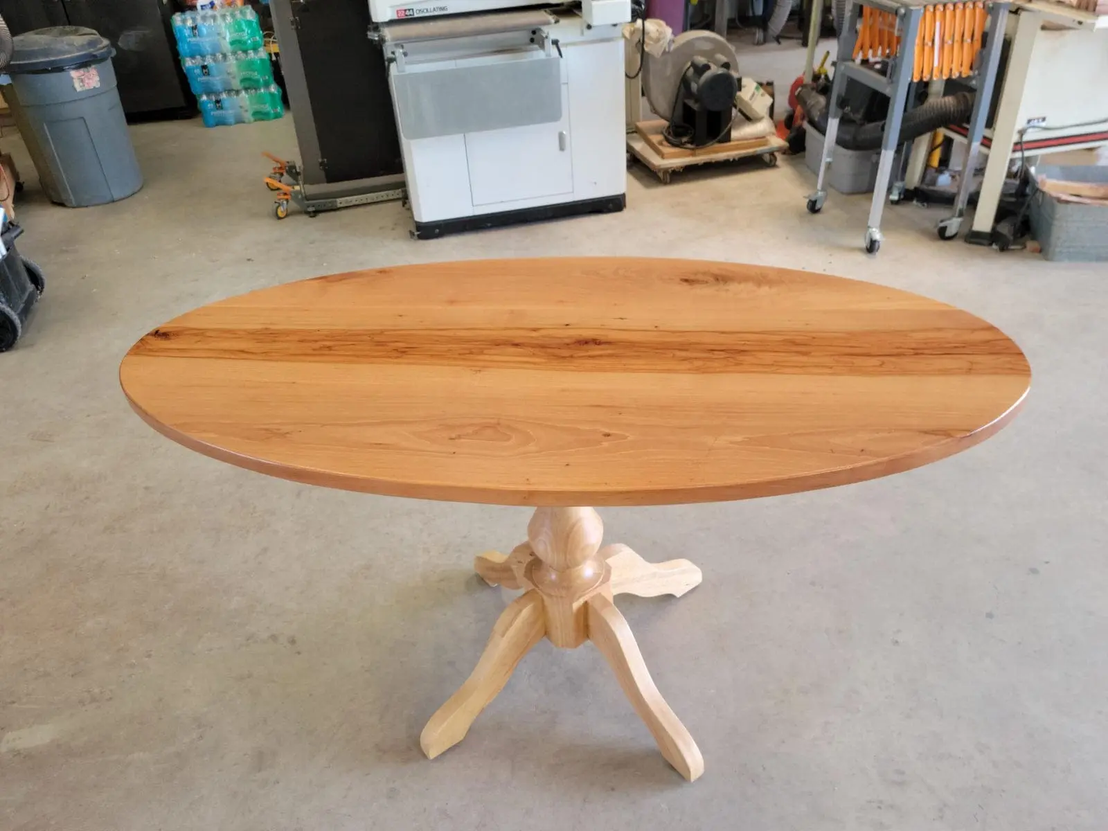 An oval pecan pedestal table in the shop