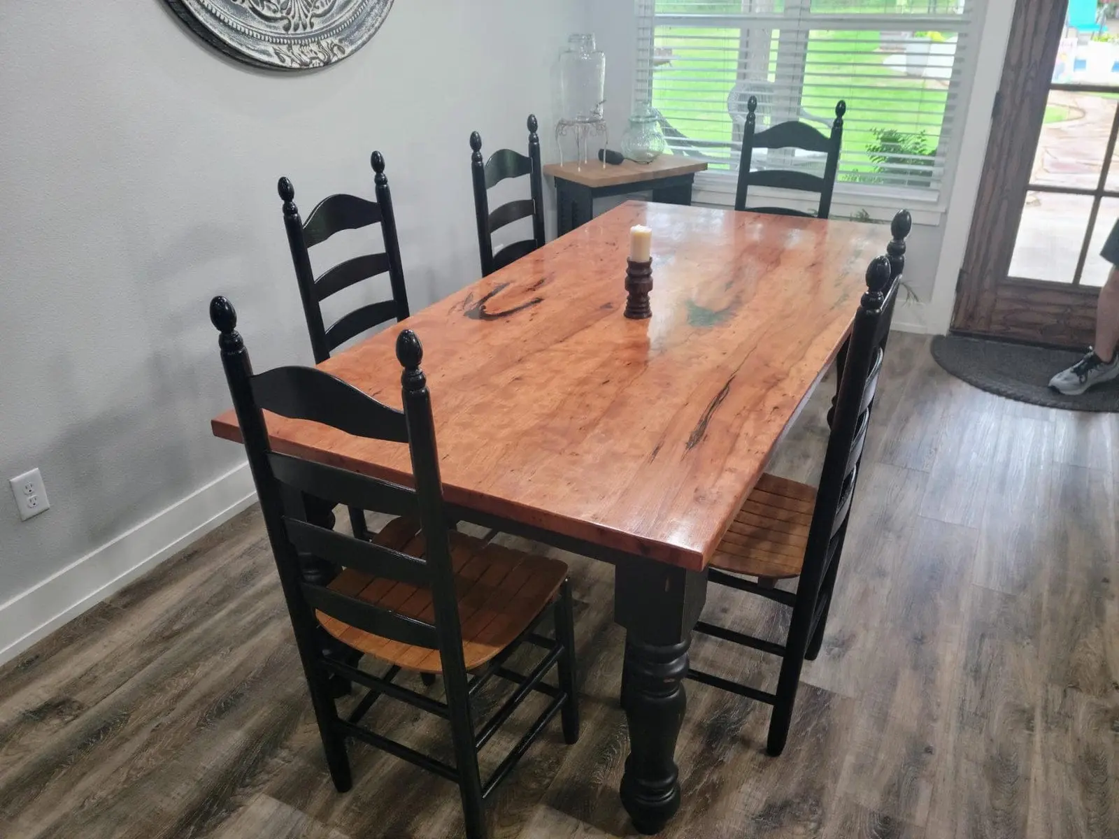 A pecan farm table with black legs in a family dining room